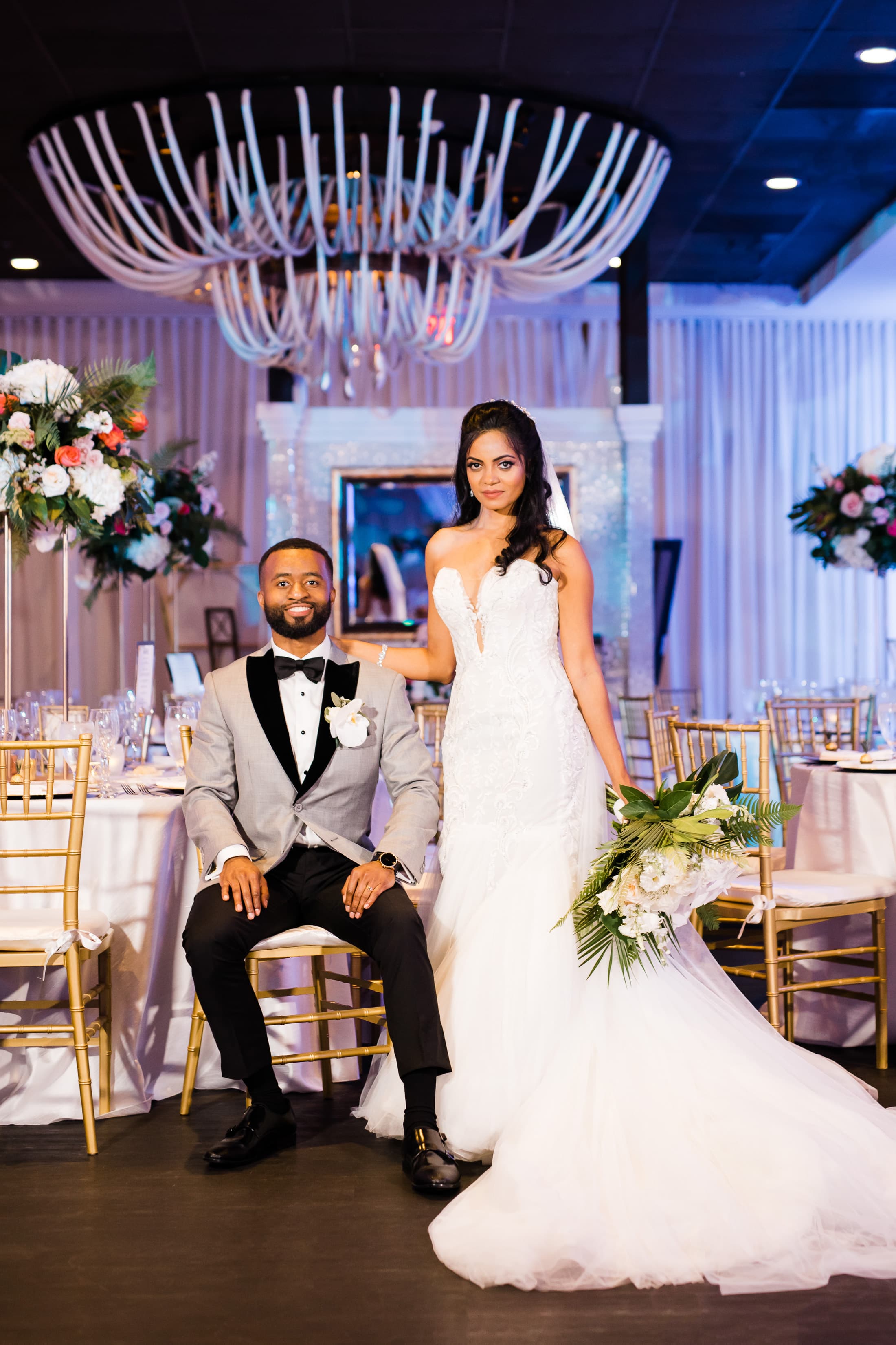 Bride and groom posing among the reception tables