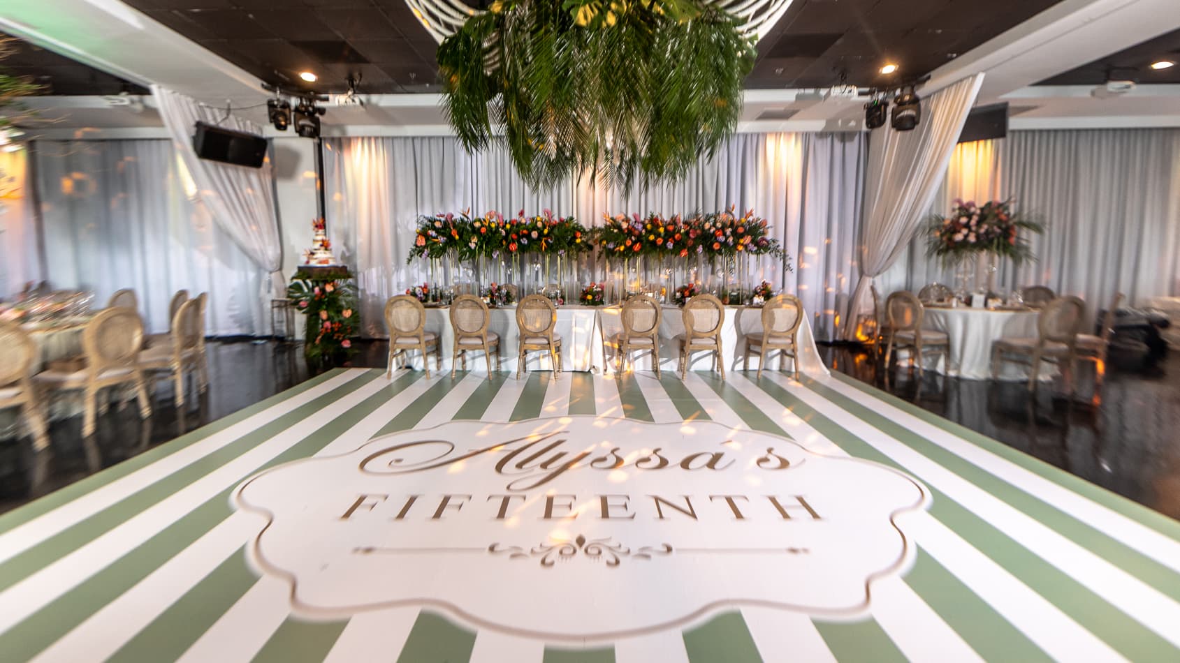 Quinceañera with a personalized striped dance floor and tropical florals