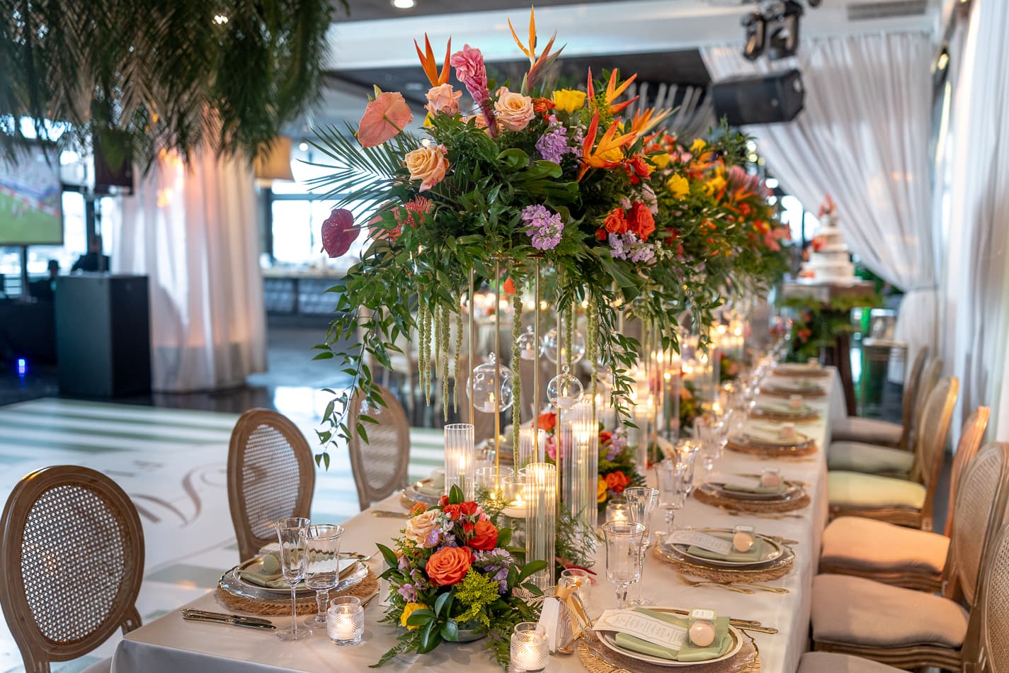 Head table dressed in tropical florals and candlelight