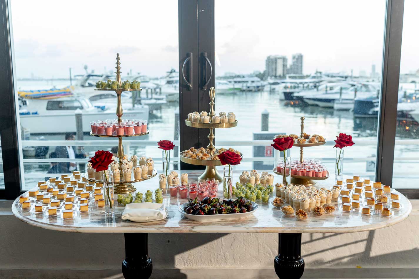 Dessert display on marble with the Venetian Marina beyond the windows